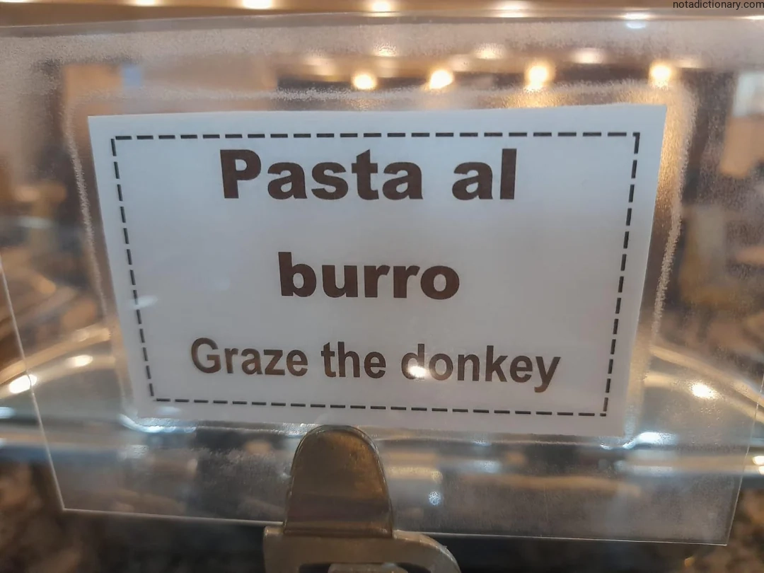 A sign in Italian and English showing the phrase 'Pasta al burro' which translates to 'Graze the donkey', illustrating a pun on the word 'burro' meaning both butter and donkey.